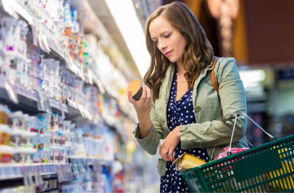 A woman in a supermarket reading a food label