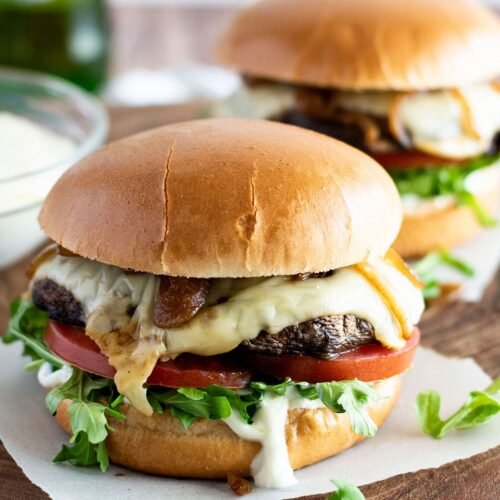 Two portobello mushroom burgers sitting on baking paper.