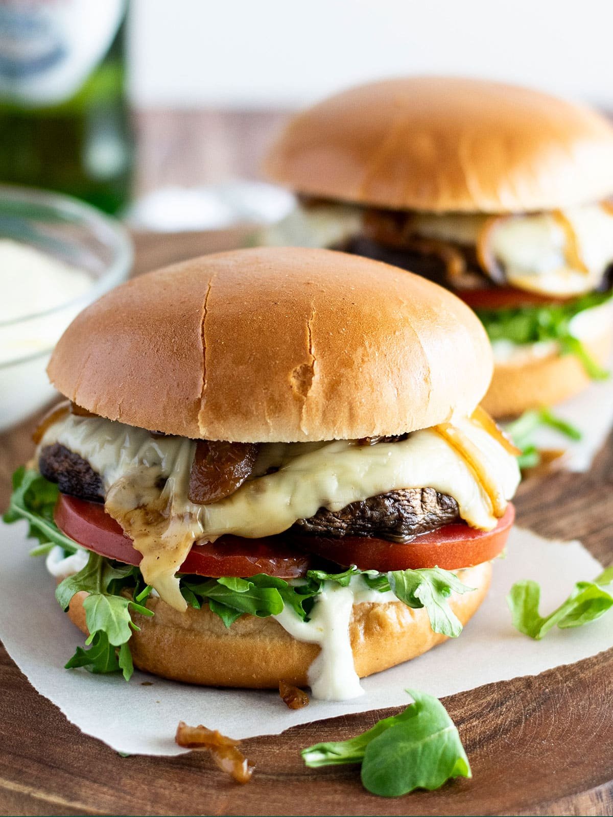 Two portobello mushroom burgers sitting on baking paper.