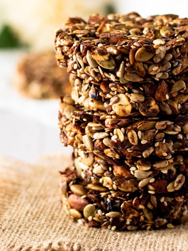 Five stacked cranberry and mixed nut cookies.