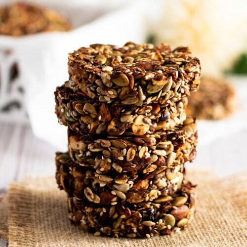 Five stacked cranberry and mixed nut cookies.