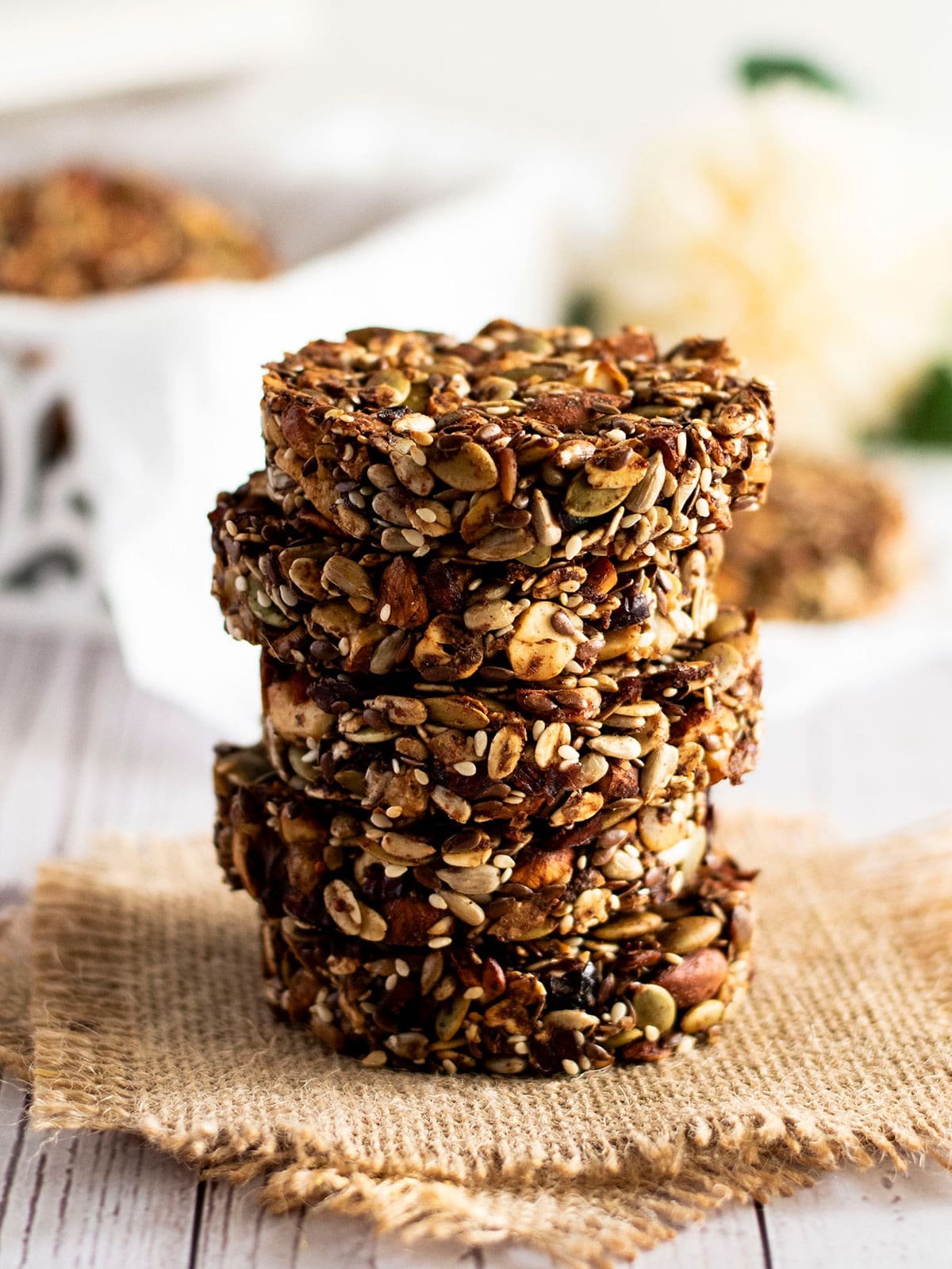 Five stacked cranberry and mixed nut cookies.