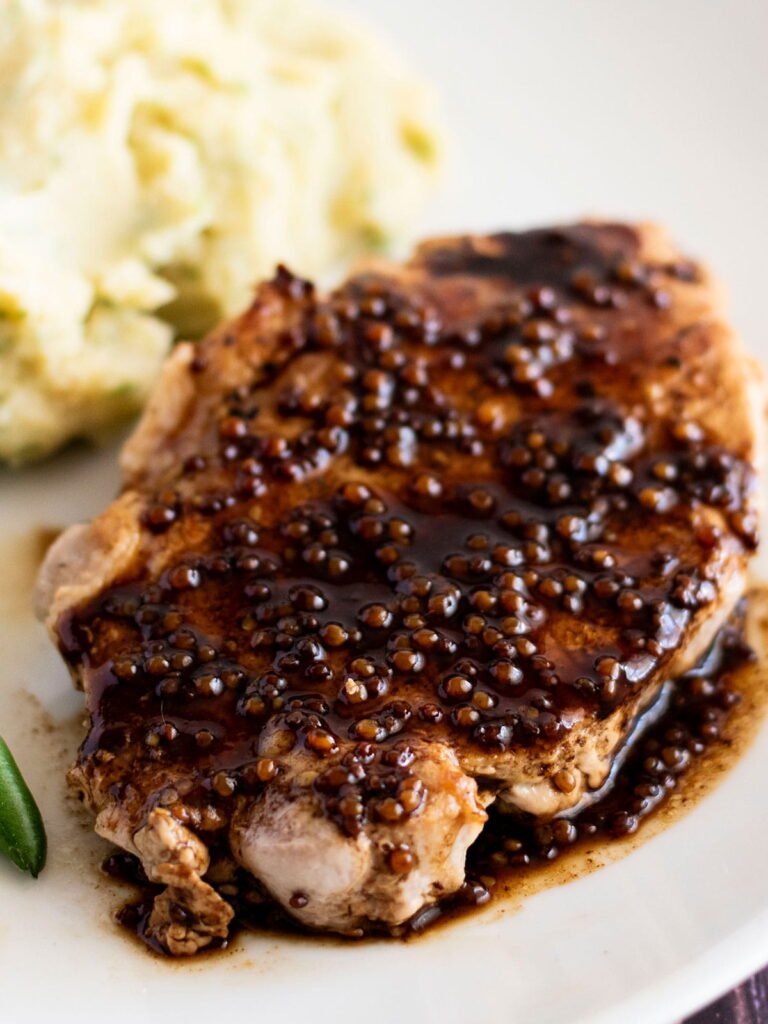 A pan fried pork steak coated in a balsamic glaze.