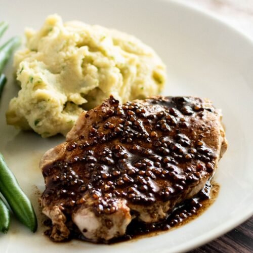 A pan fried pork steak covered in a balsamic reduction with wholegrain mustard.