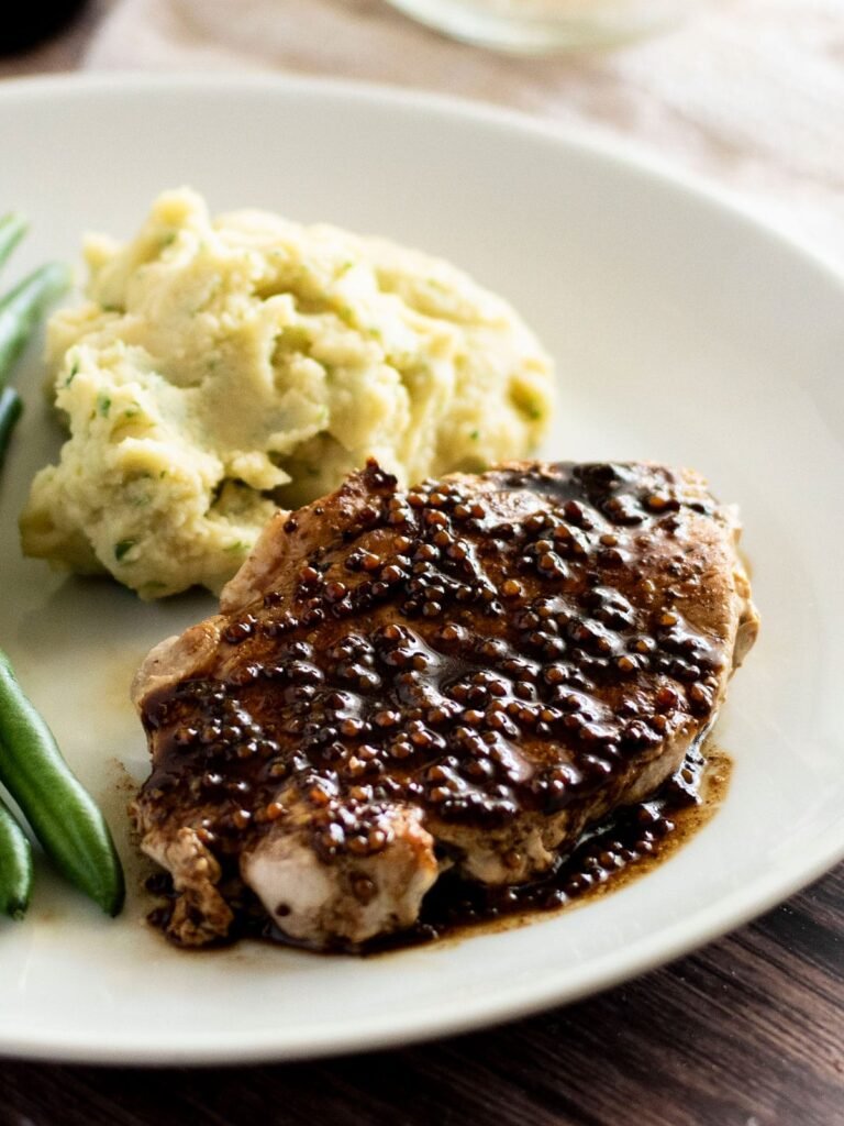 A pan fried pork steak covered in a balsamic reduction with wholegrain mustard.