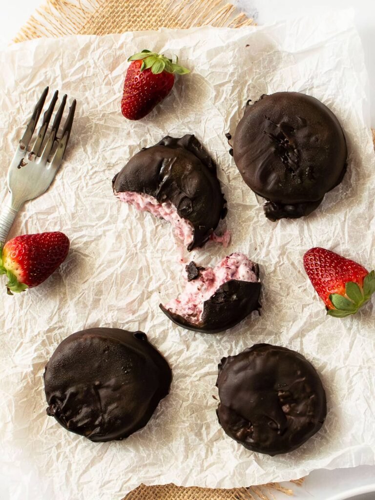 Overhead view of frozen strawberry and Greek yogurt bites on baking paper.