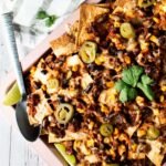 A sheet pan full of beef and bean nachos.