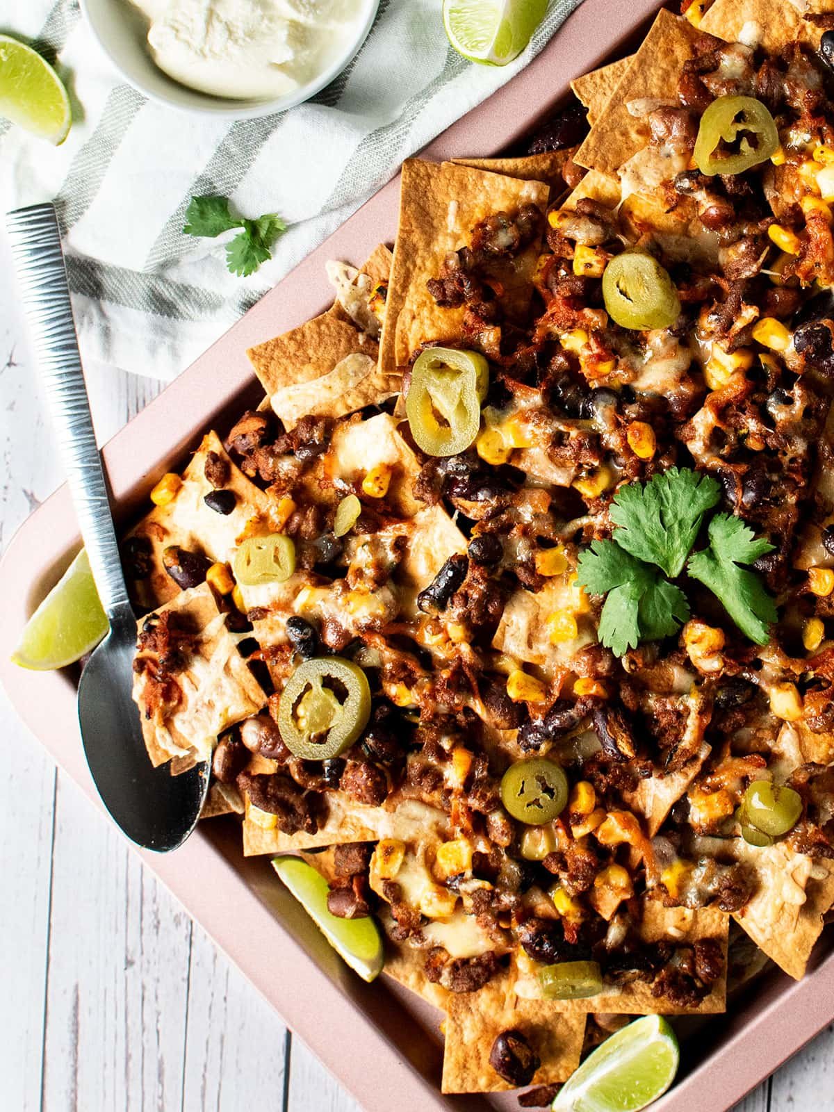 A sheet pan full of beef and bean nachos.