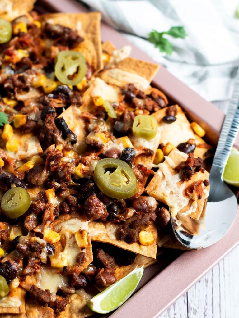 A sheet pan full of beef and bean nachos.