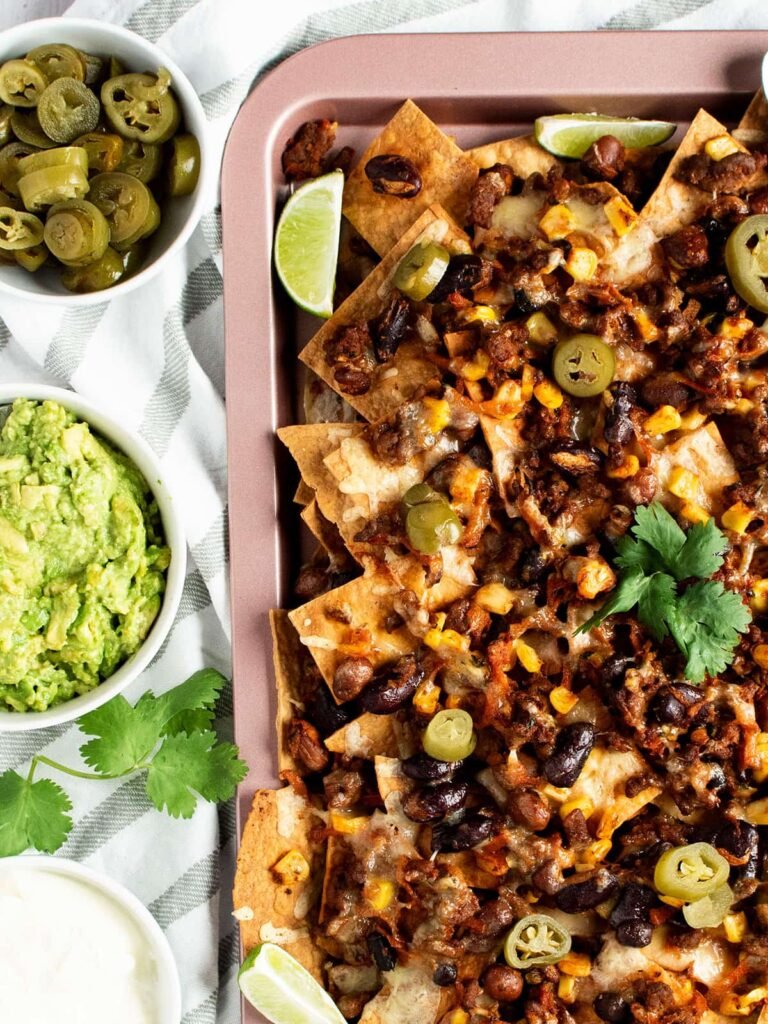 A sheet pan full of beef and bean nachos.