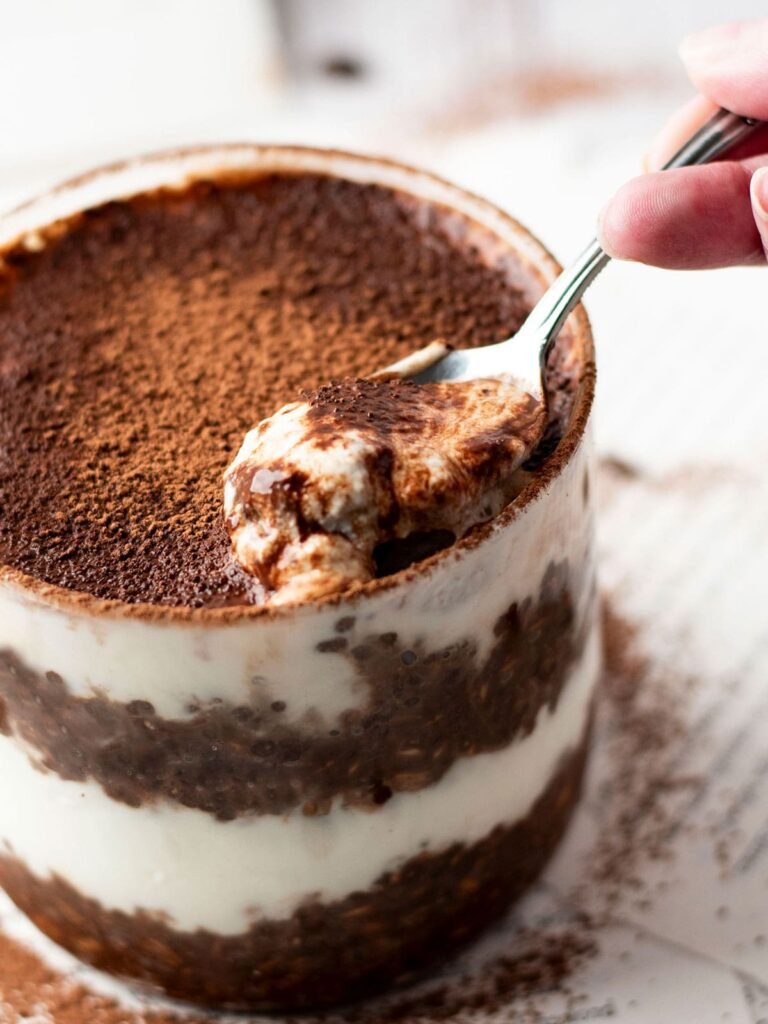 A spoon taking a scoop our of a canister of Tiramisu overnight oats.