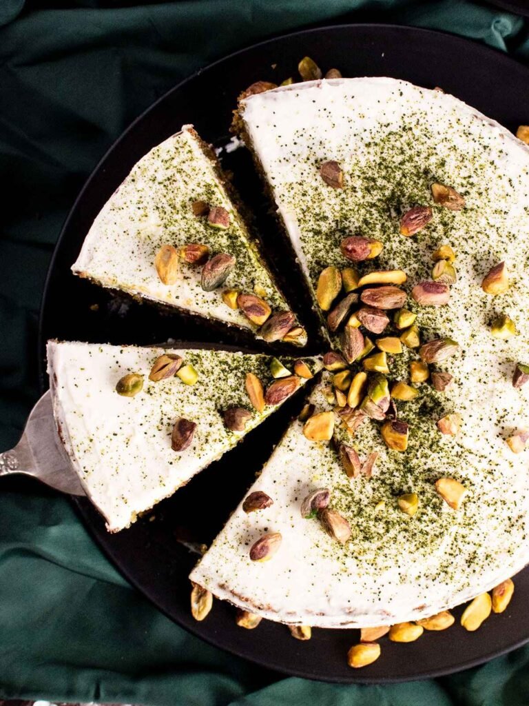 A pistachio and matcha cake with 2 slices cut out.