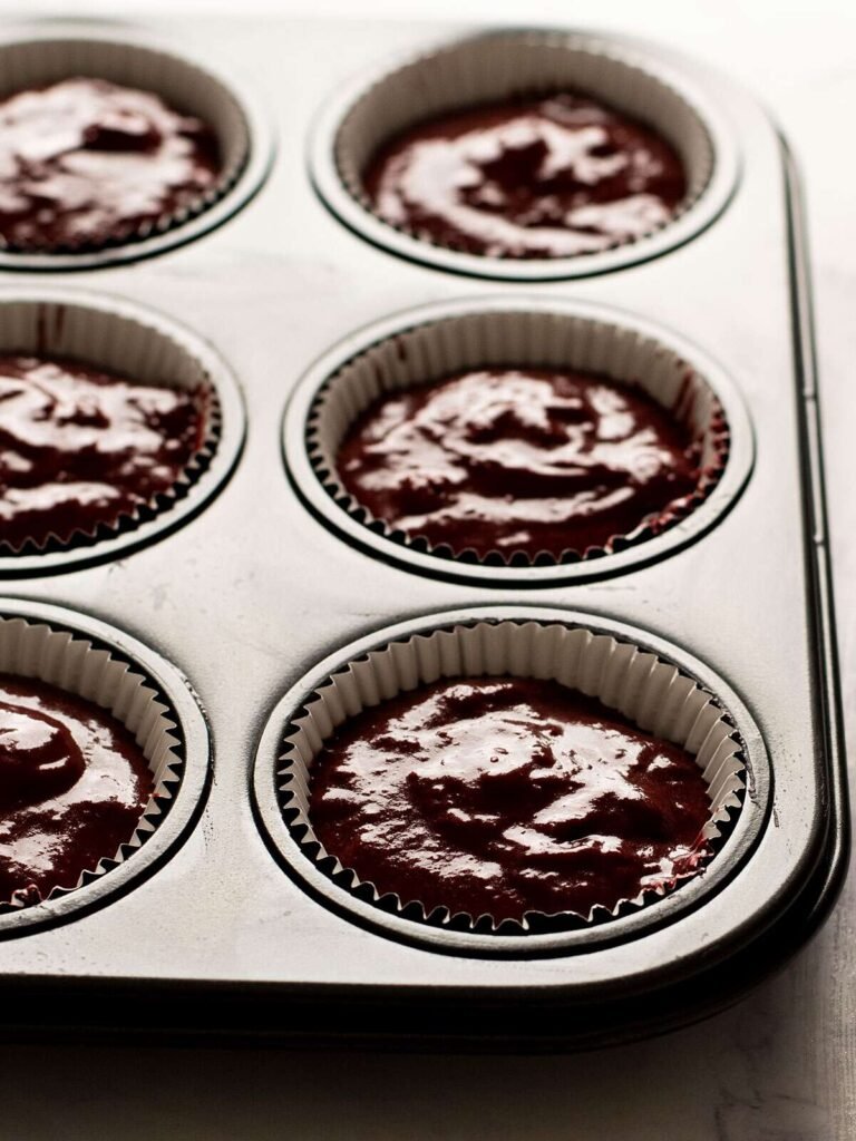 Chocolate beetroot cupcake batter in a muffin pan.